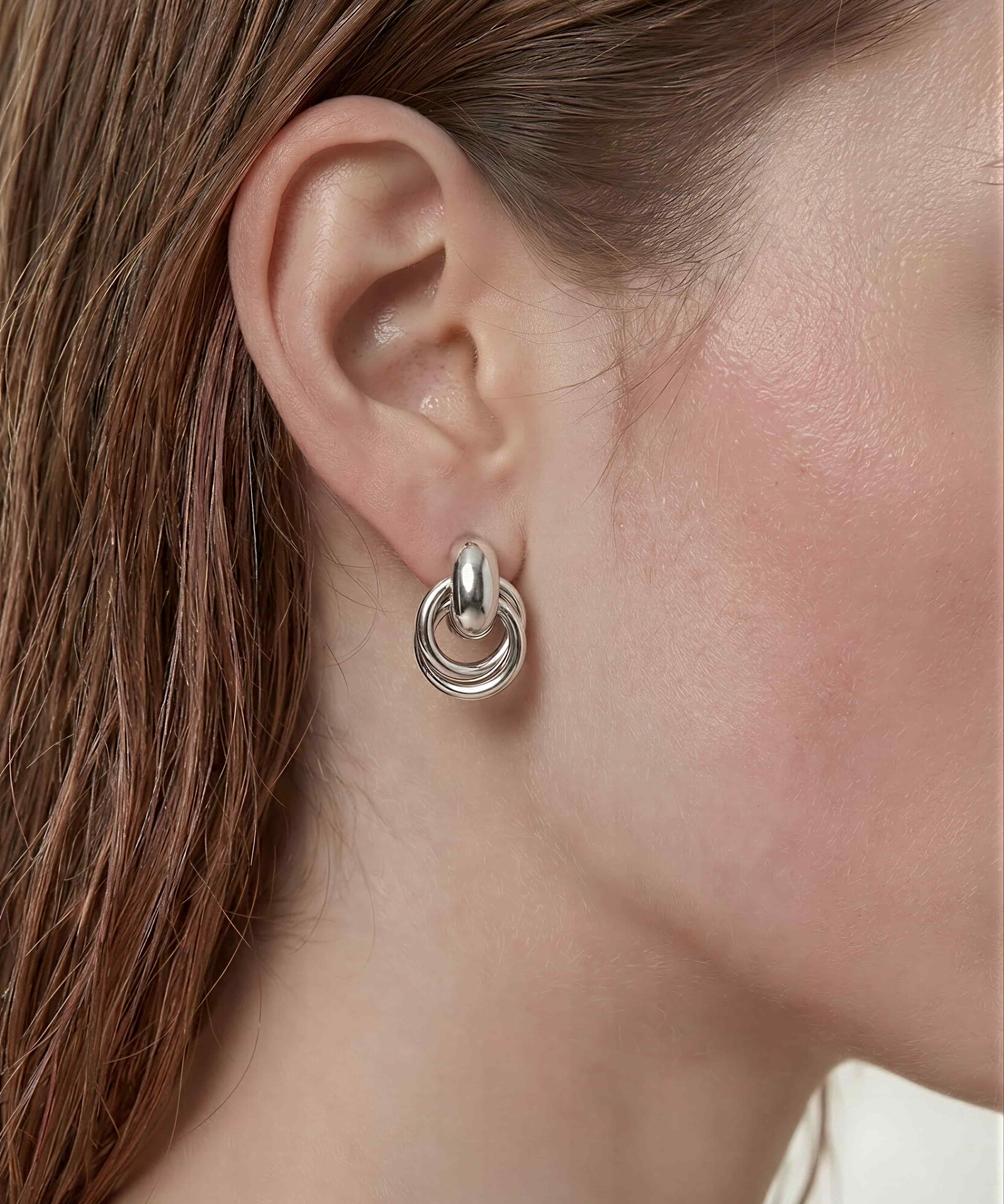 Sculpted interlock drop earrings in 925 silver plated finish featuring smooth polished layered loop design.