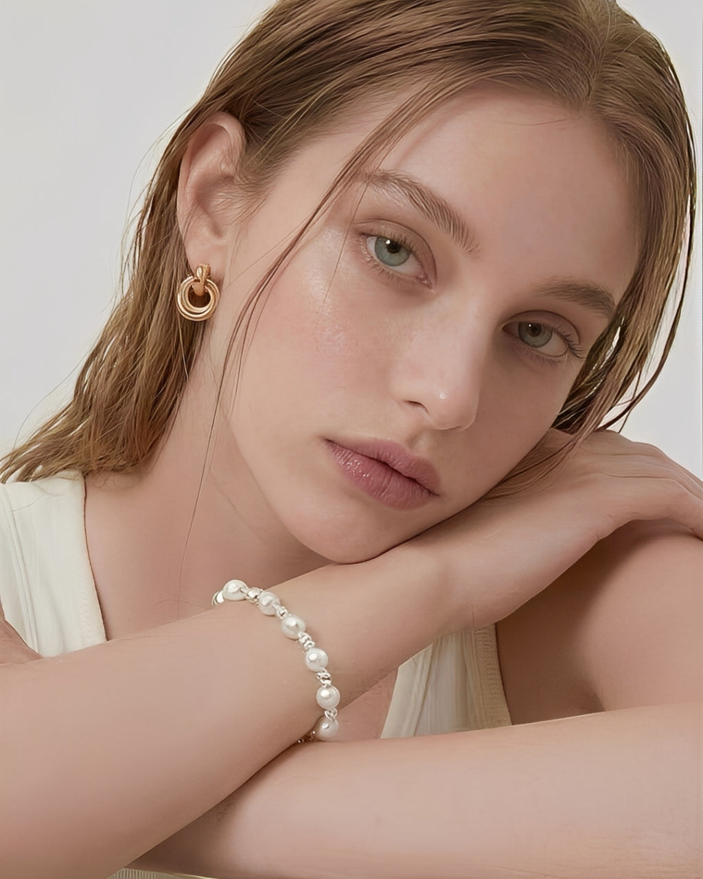 Model wearing About Ease interlinked loop stud earrings in a minimalist gold design with a clean, modern aesthetic