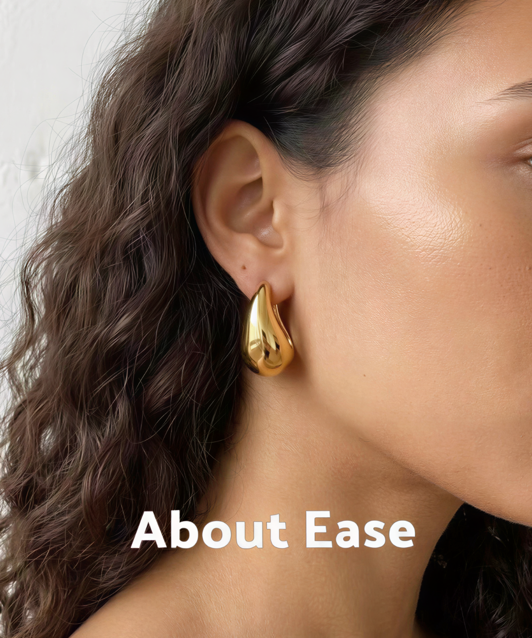 Model wearing About Ease soft drop gold stud earrings with a polished minimalist teardrop design