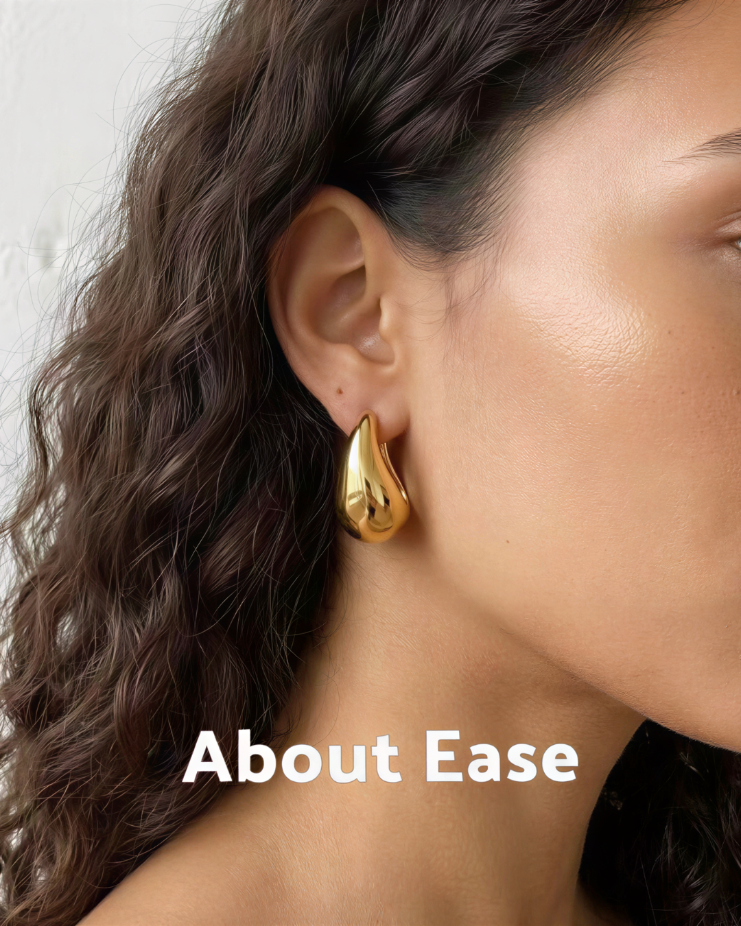 Model wearing About Ease soft drop gold stud earrings with a polished minimalist teardrop design