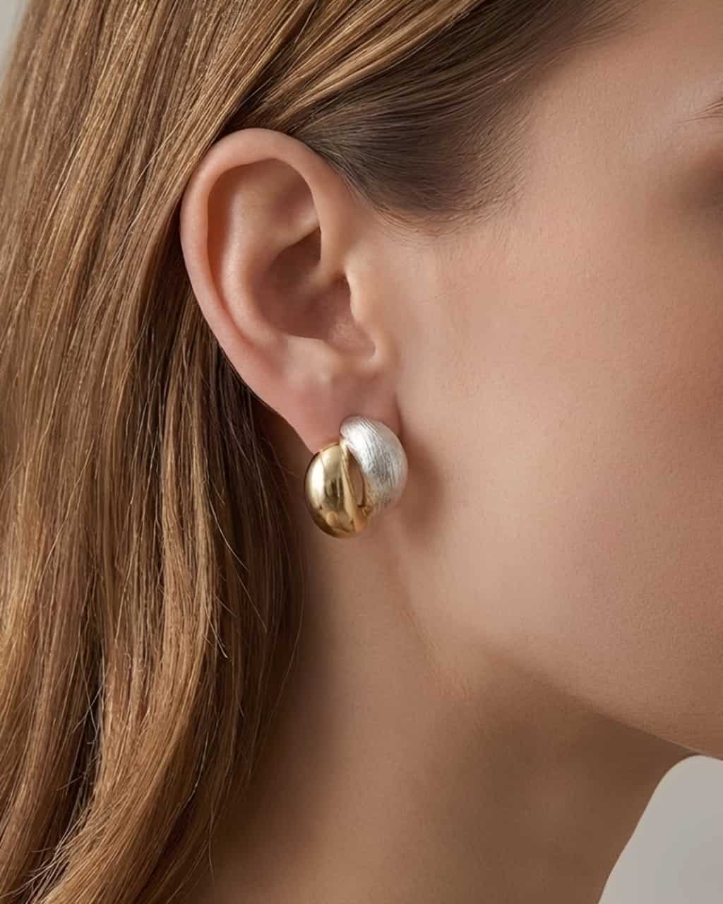 Dual Tone Sculpt Stud Earrings worn on ear, minimalist two-tone stud earrings with brushed and polished finishes