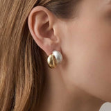 Dual Tone Sculpt Stud Earrings worn on ear, minimalist two-tone stud earrings with brushed and polished finishes