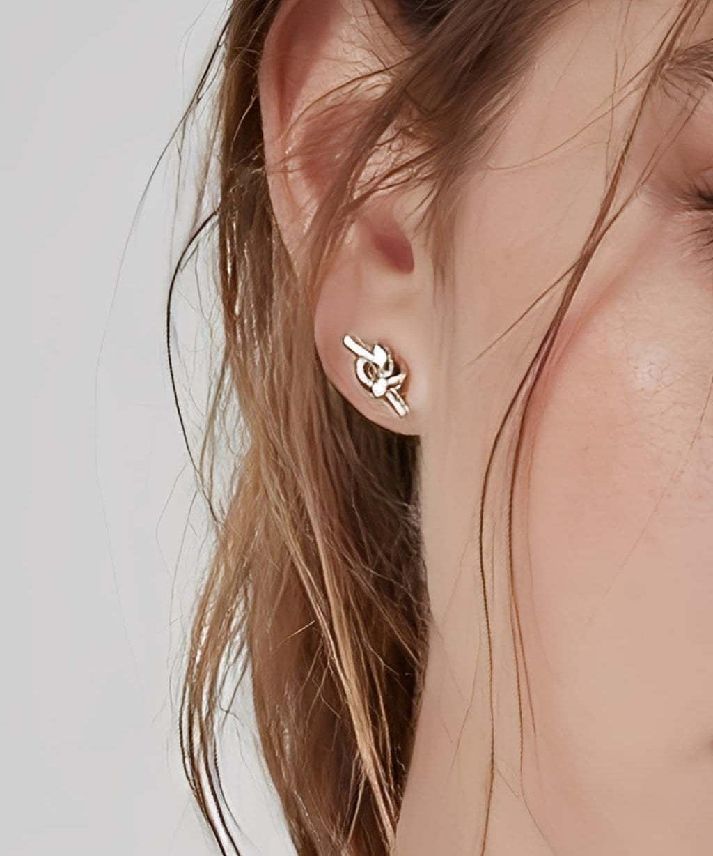 Essential Knot Stud Earrings worn on ear, minimalist knot stud earrings with a polished finish