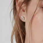 Essential Knot Stud Earrings worn on ear, minimalist knot stud earrings with a polished finish