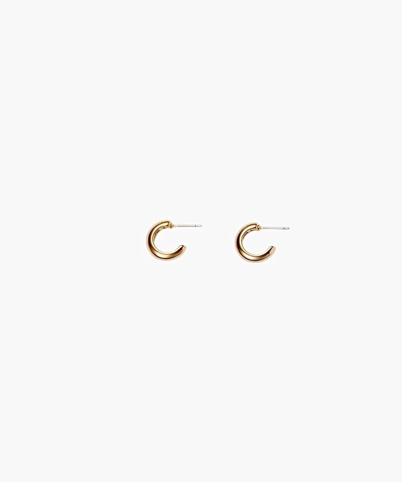 Close-up of gold chunky hoop earrings with polished minimalist design