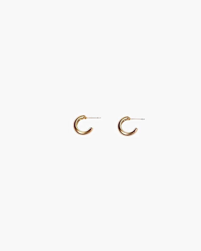 Close-up of gold chunky hoop earrings with polished minimalist design