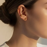 Model wearing gold cluster dot stud earrings styled as a minimalist ear stack with modern 18K gold plated ball studs and ear cuff detail.