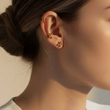 Model wearing gold cluster dot stud earrings styled as a minimalist ear stack with modern 18K gold plated ball studs and ear cuff detail.