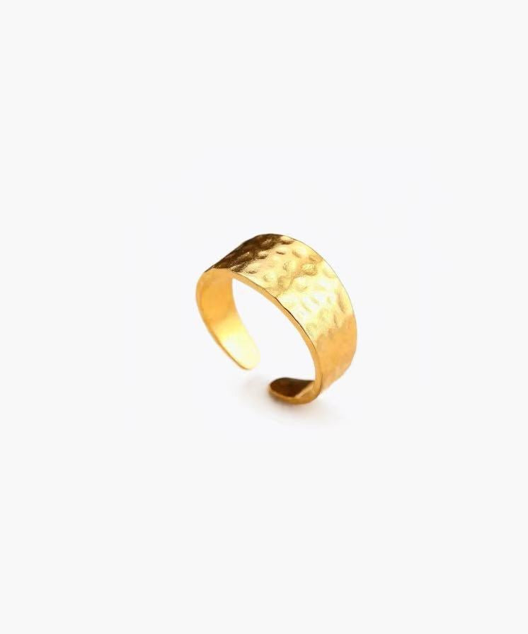 Hammered band ring in stainless steel with silver and 18K gold plated finishes, featuring a textured surface and adjustable open band