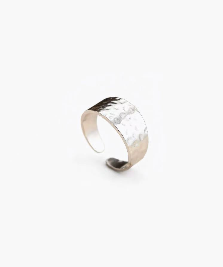 Hammered band ring in stainless steel with silver and 18K gold plated finishes, featuring a textured surface and adjustable open band