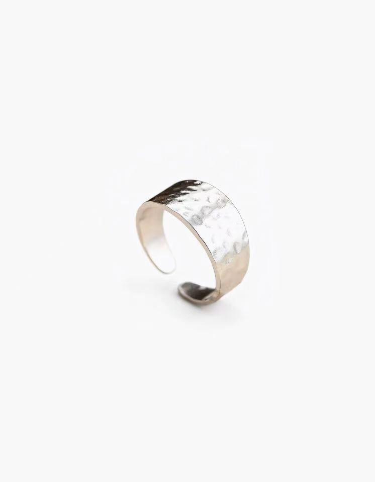 Hammered band ring in stainless steel with silver and 18K gold plated finishes, featuring a textured surface and adjustable open band