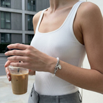 horseshoe pearl bracelet worn with casual outfit minimalist style