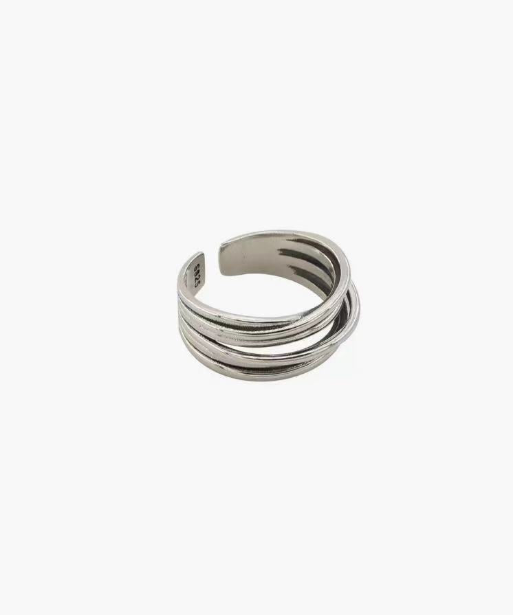 Layered Curve Ring in stainless steel with overlapping curved bands and an adjustable open design