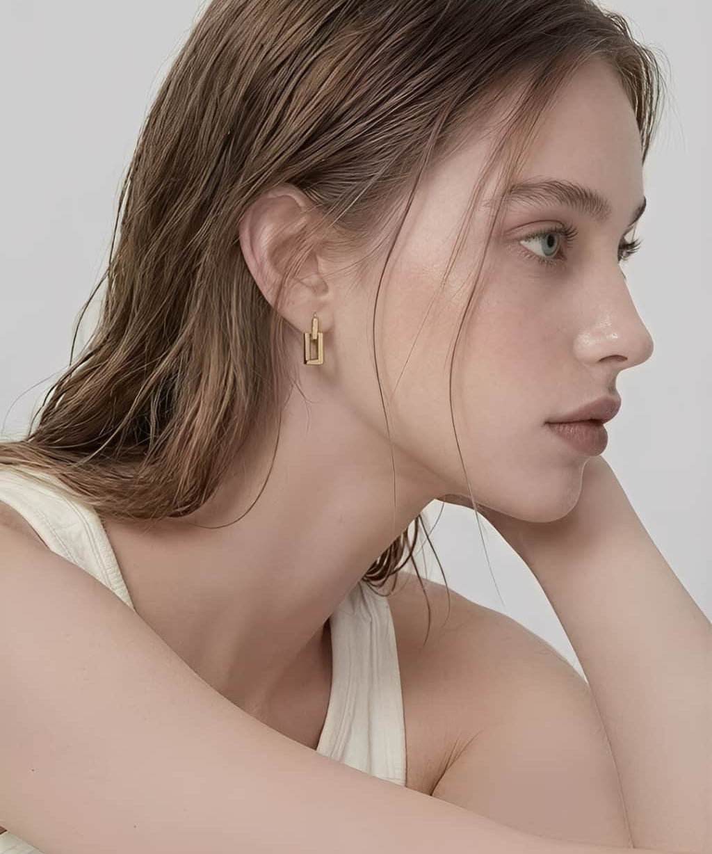 Linear Frame Earrings worn on ear, minimalist geometric drop earrings with a clean rectangular design