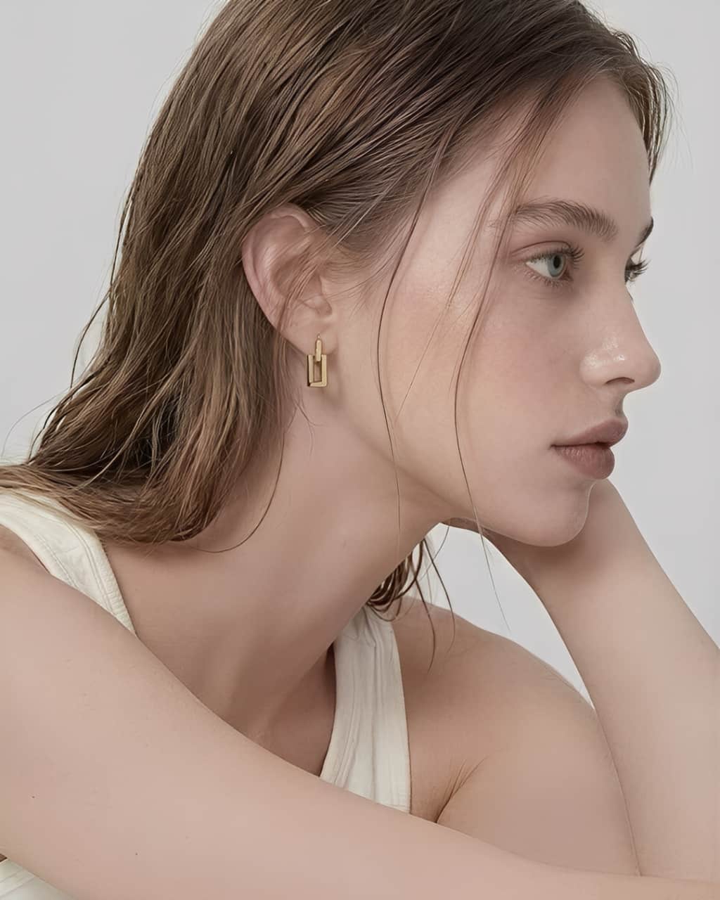 Linear Frame Earrings worn on ear, minimalist geometric drop earrings with a clean rectangular design