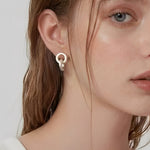 Model wearing linked form silver stud earrings with a minimalist sculptural design
