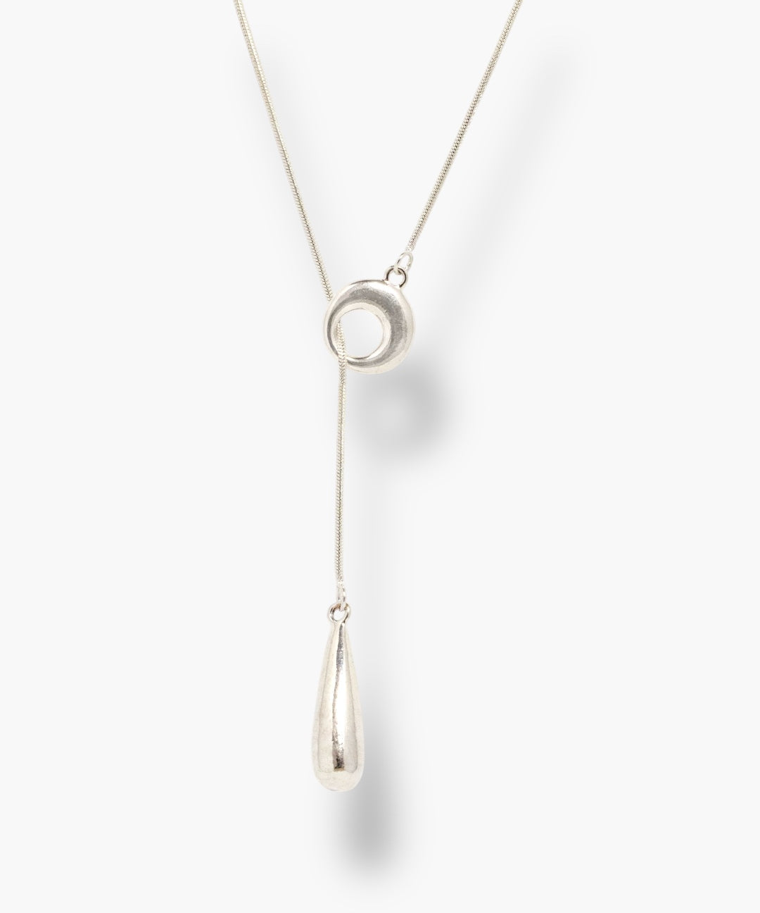 Minimal silver linear drop necklace with circular pendant and long teardrop charm.
