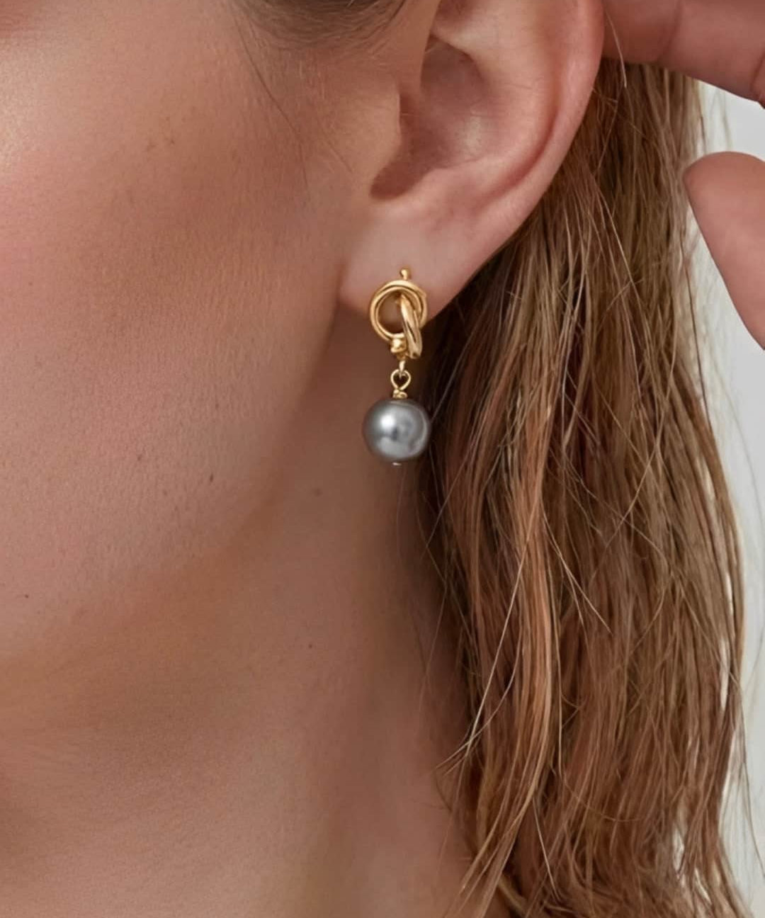 Modern Pearl Drop Earrings worn on ear, minimalist drop earrings with a gray pearl and refined gold-tone detail