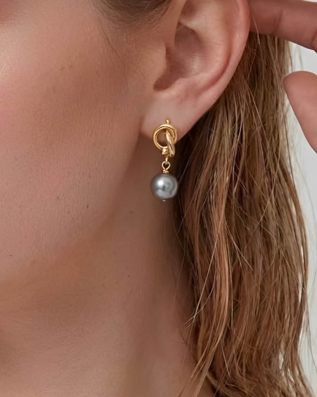 Modern Pearl Drop Earrings worn on ear, minimalist drop earrings with a gray pearl and refined gold-tone detail