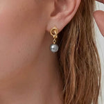 Modern Pearl Drop Earrings worn on ear, minimalist drop earrings with a gray pearl and refined gold-tone detail