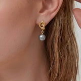Modern Pearl Drop Earrings worn on ear, minimalist drop earrings with a gray pearl and refined gold-tone detail