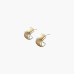 Quiet Curve Huggie Earrings in gold tone with brushed finish and polished edges, curved huggie style.