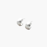 Quiet Curve Huggie Earrings in silver tone with brushed finish and polished edges, minimalist curved design.