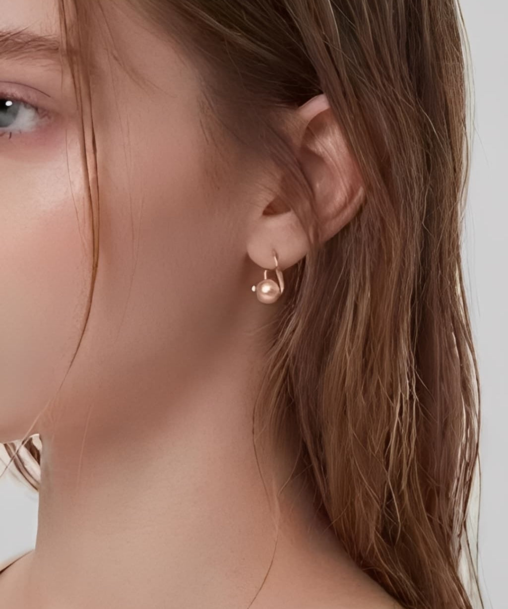 Quiet Pearl Hook Earrings worn on ear, minimalist hook earrings with a delicate pearl drop
