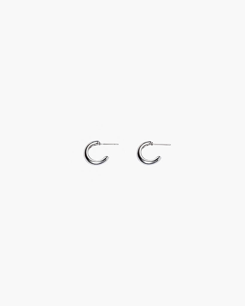 Close-up of silver chunky hoop earrings with polished minimalist design
