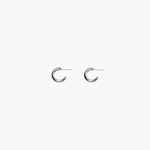 Close-up of silver chunky hoop earrings with polished minimalist design
