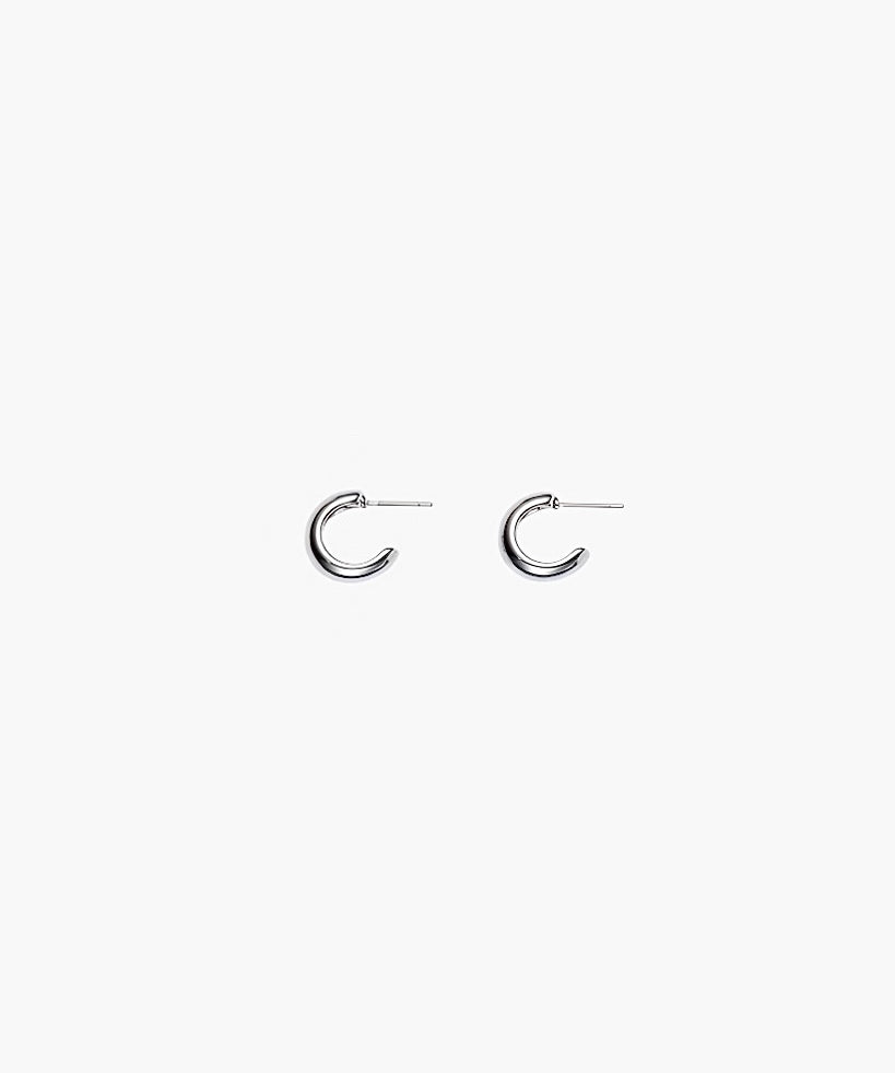 Close-up of silver chunky hoop earrings with polished minimalist design