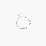 Silver ribbon accent bracelet with delicate bow details and adjustable chain closure in minimalist design.
