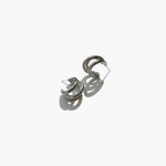 Silver triple hoop earrings with minimalist modern design on white background