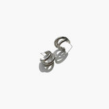 Silver triple hoop earrings with minimalist modern design on white background