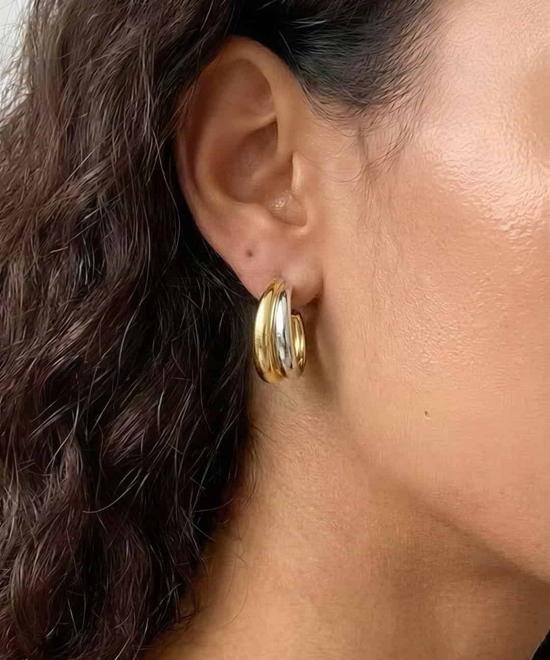 Soft Curve Earrings worn on ear, minimalist platinum-plated hoop earrings with a smooth curved design