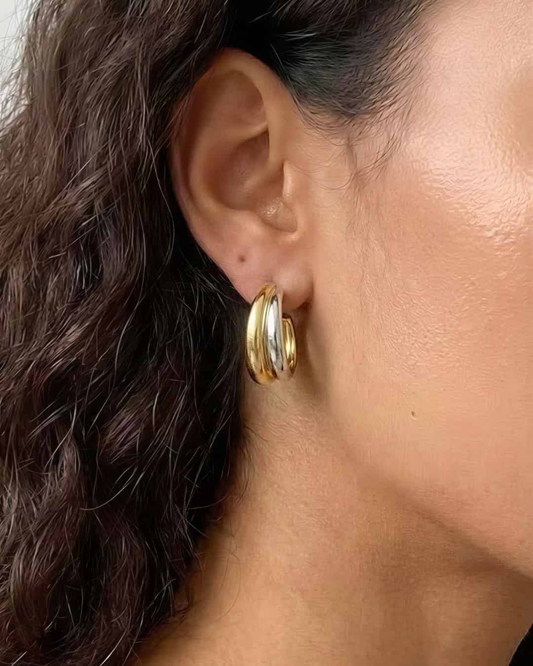 Soft Curve Earrings worn on ear, minimalist platinum-plated hoop earrings with a smooth curved design