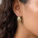 Soft Curve Earrings worn on ear, minimalist platinum-plated hoop earrings with a smooth curved design